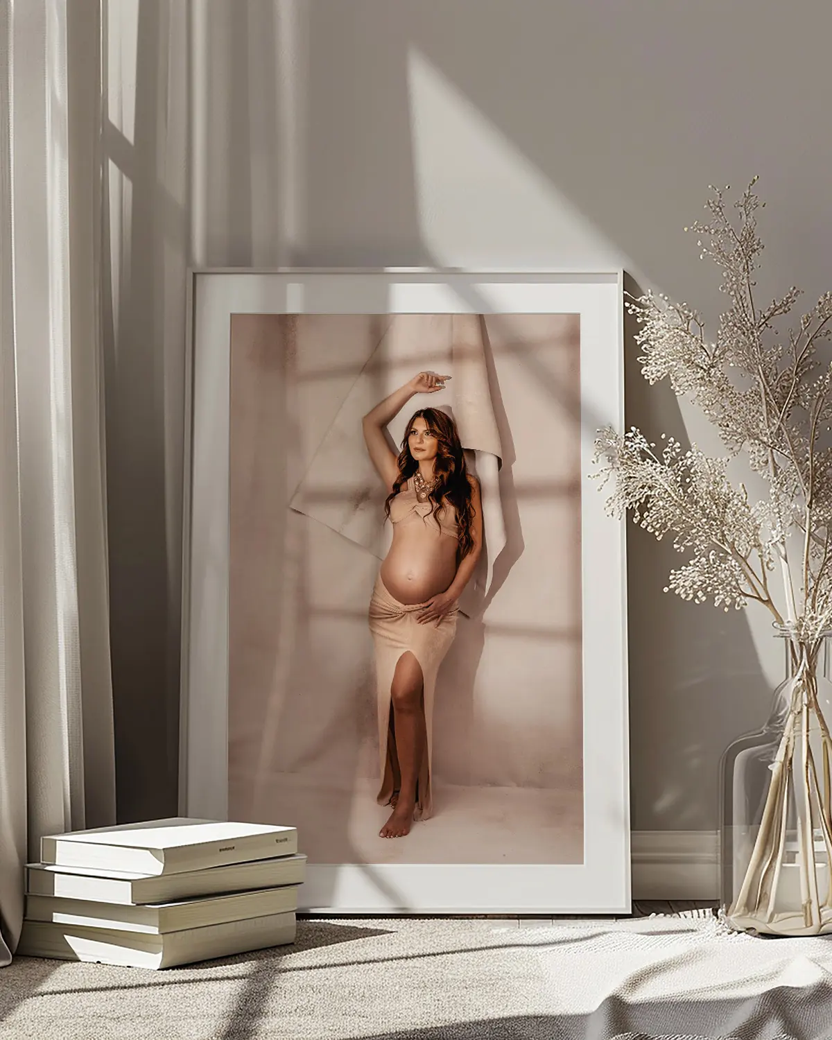 Portrait de future maman encadré comme un tableau, posé contre un mur