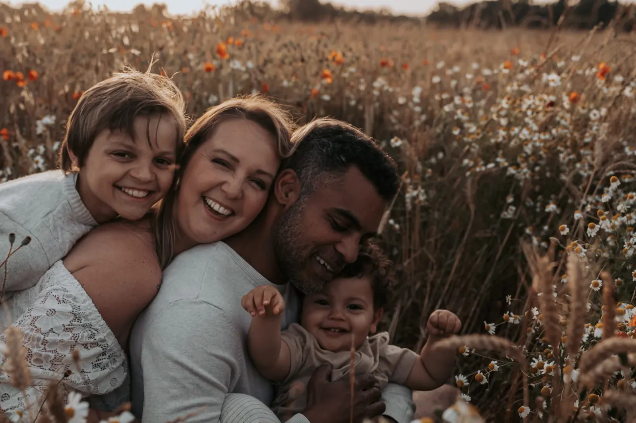 Famille qui rit aux éclats dans un champ